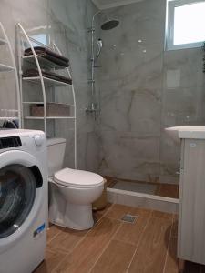 a bathroom with a toilet and a washing machine at Blue Sky Villa in Kalithies +28 photos