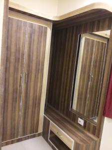 a bathroom with two wooden cabinets and a mirror at HOTEL R K RESIDENCY MUZAFFARPUR in Muzaffarpur