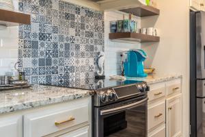 uma cozinha com azulejos pretos e brancos na parede em The Periwinkle - 344 Audubon home em Dauphin Island