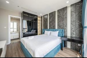 Schlafzimmer mit einem großen Bett mit blauem Kopfteil in der Unterkunft Vinhome Landmark Suites in Ho-Chi-Minh-Stadt