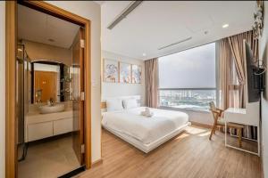 a bedroom with a bed and a bathroom with a sink at Vinhome Landmark 81 Suites in Ho Chi Minh City +151 photos