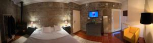 a hotel room with a bed and a tv at Villa Candoso in Candoso