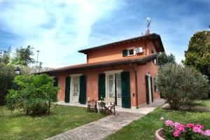 uma pequena casa vermelha com uma mesa num quintal em Relais Villa Isabel em Pietrasanta