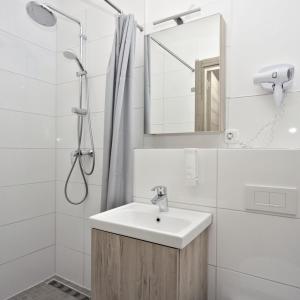 ein weißes Badezimmer mit einem Waschbecken und einem Spiegel in der Unterkunft C & N Hotel - an der Messe München in München