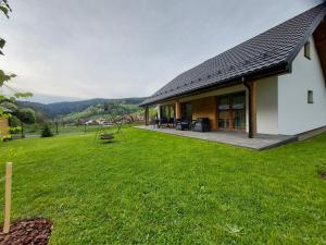 a house with a large yard next to a building at Domek na Duzynie in Ochotnica Górna