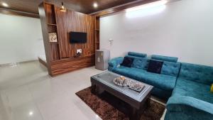 un soggiorno con divano blu e tavolo di 1heaven - Home Stay a Sahaspur