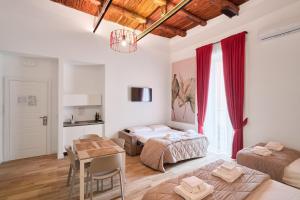 a bedroom with two beds and a table in it at Toto e Peppino luxury rooms in Naples
