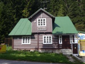 a small wooden building with a green roof at Penzion Mikeš in Pec pod Sněžkou