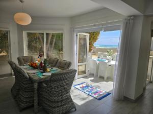 un soggiorno con tavolo, sedie e vista sull'oceano di Sandy Coast Beach Villa a Larnaka