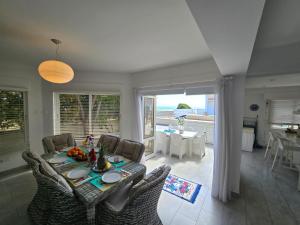 una sala da pranzo con tavolo e sedie e vista sull'oceano di Sandy Coast Beach Villa a Larnaka Altre 20 foto