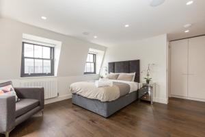 a bedroom with a bed and a couch and a chair at Penthouse with Private Terrace Soho - CityApartmentStay in London