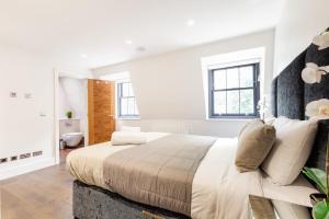a white bedroom with a large bed with white walls at Penthouse with Private Terrace Soho - CityApartmentStay in London