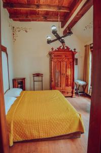 1 dormitorio con cama amarilla y armario de madera en Casa de los Arcángeles en San Cristóbal de Las Casas
