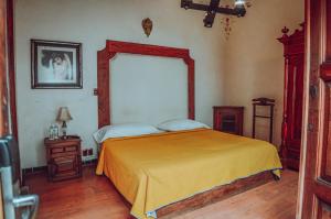 een slaapkamer met een bed en een grote spiegel bij Casa de los Arcángeles in San Cristóbal de Las Casas