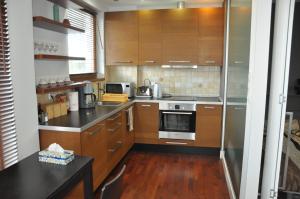 a kitchen with wooden cabinets and a stove top oven at Apartament Mokotow in Warsaw