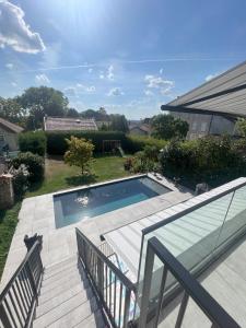 イエールにあるBelle maison avec piscine à 30 min de Parisのデッキとパティオ付きの庭のスイミングプールを利用できます。