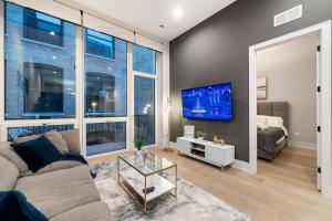 a living room with a couch and a tv at Chic River North Condo 2BR 2BA with Private Balcony in Chicago