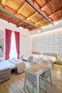 a room with four beds and a table in it at Toto e Peppino luxury rooms in Naples