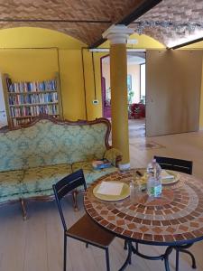ein Wohnzimmer mit einem Tisch und einem Sofa in der Unterkunft B&BLe Tre Gemme in Montechiarugolo