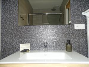 ein weißes Waschbecken im Bad mit Spiegel in der Unterkunft Gite Les Intemporels in Cuisery