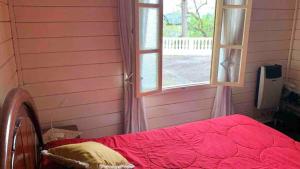 un letto in una stanza con una finestra di SÍTIO ALTO DA COLINA a Nova Friburgo