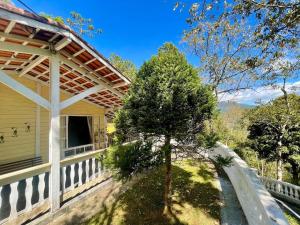 una casa con una recinzione e un albero accanto di SÍTIO ALTO DA COLINA a Nova Friburgo