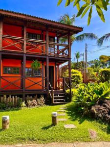 a red house with a green yard in front of it at Pousada Chalés Sinbad in Ilhabela