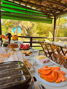 a table with plates of food on top at Pousada Chalés Sinbad in Ilhabela