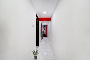 a hallway with white walls and a red ceiling at OYO Flagship White Inn Near Golden Tower in Chennai