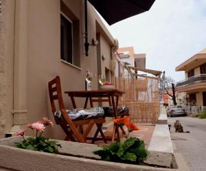 a table and chair on the side of a building with flowers at Cathy's Place in Paradeísion