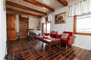 a living room with red chairs and a table at Serenity in Dramlje