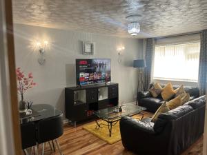 a living room with a couch and a table at Charming 2-Bedroom in MANCHESTER in Manchester
