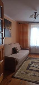 uma sala de estar com um sofá e uma janela em Pokoje nad jeziorem Mazury em Dabrówno