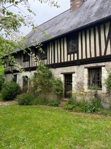 an old black and white house with a green yard at The Manor of Vattetot, historical landmark XII-XVI century in Vattetot-sur-Mer