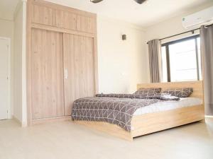 a bedroom with a bed and a large wooden cabinet at SERENE HAVEN RETREAT in Accra