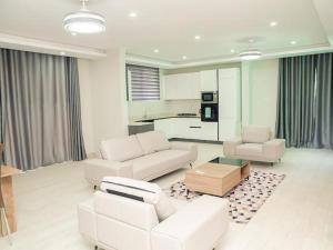 a living room with white furniture and a kitchen at SERENE HAVEN RETREAT in Accra