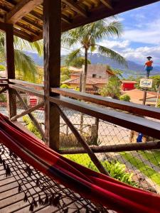 a hammock on a porch with a view of the ocean at Pousada Chalés Sinbad in Ilhabela