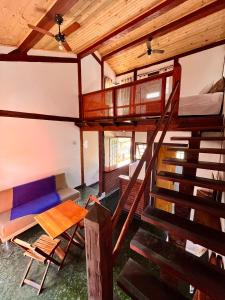 a room with a staircase and a bed and a couch at Pousada Chalés Sinbad in Ilhabela