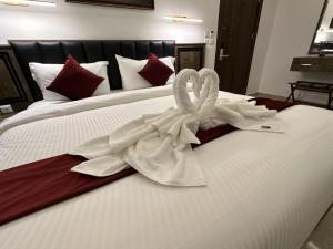 Petra Bermudez Hotel في وادي موسى: يوجد بجعتين للمناشف على سرير