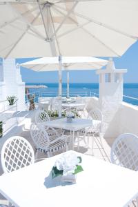 a white table and chairs with the ocean in the background at Hotel Don Ferrante in Monopoli
