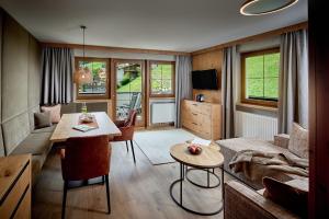 uma sala de estar com uma mesa e um sofá em Hotel Alpenhof em Tux