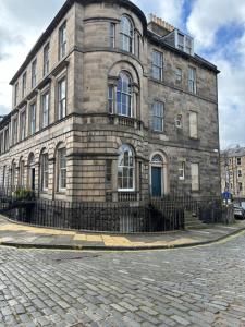 un grande edificio in pietra su una strada di ciottoli di Cosy Georgian Flat a Edimburgo