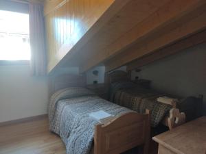 two twin beds in a room with a attic at Appartamenti Meoti in Pellizzano
