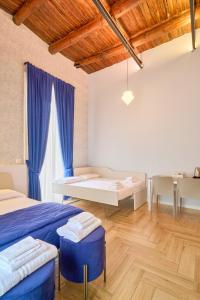 a bedroom with two beds and a desk in it at Toto e Peppino luxury rooms in Naples