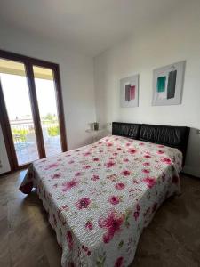 1 Schlafzimmer mit einem Bett mit Blumenbettdecke und einem Fenster in der Unterkunft Casa Emy, tranquilla, ottima per Rilassarsi in Montinelle
