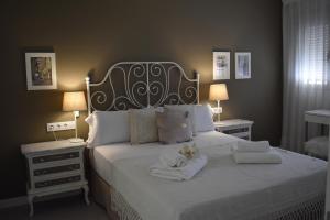 a bedroom with a large white bed with two night stands at Precioso piso en el centro de Almeria in Almería