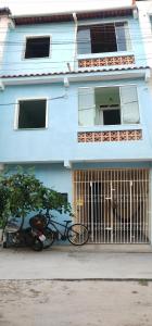a bike parked in front of a blue house at Apartamento Favo de Mel 1 in Suape