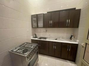 a small kitchen with a stove and a sink at منتجع واستراحة اليخت in Khalij Salman