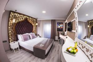 a hotel room with a bed and a table with a bowl of fruit at Demonti Hotel in Ankara