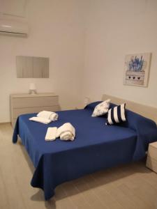 - un lit bleu avec des serviettes dans l'établissement Al Quindici, à Gaète